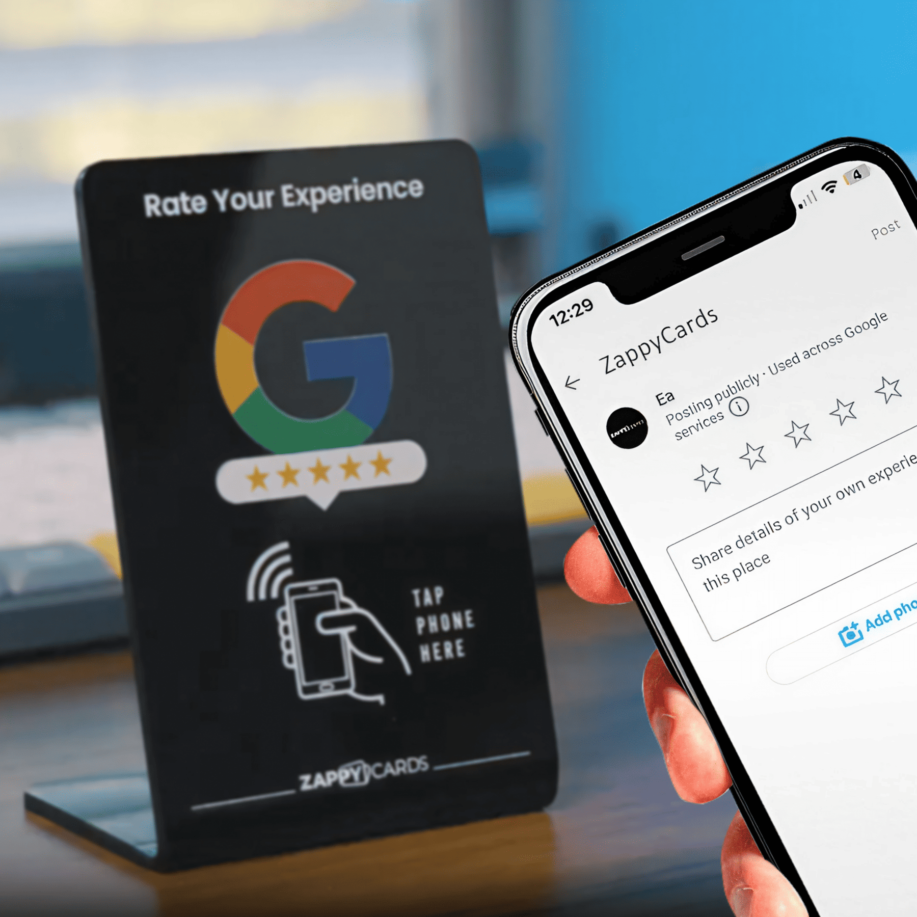 Person holding a phone beside a Google review stand